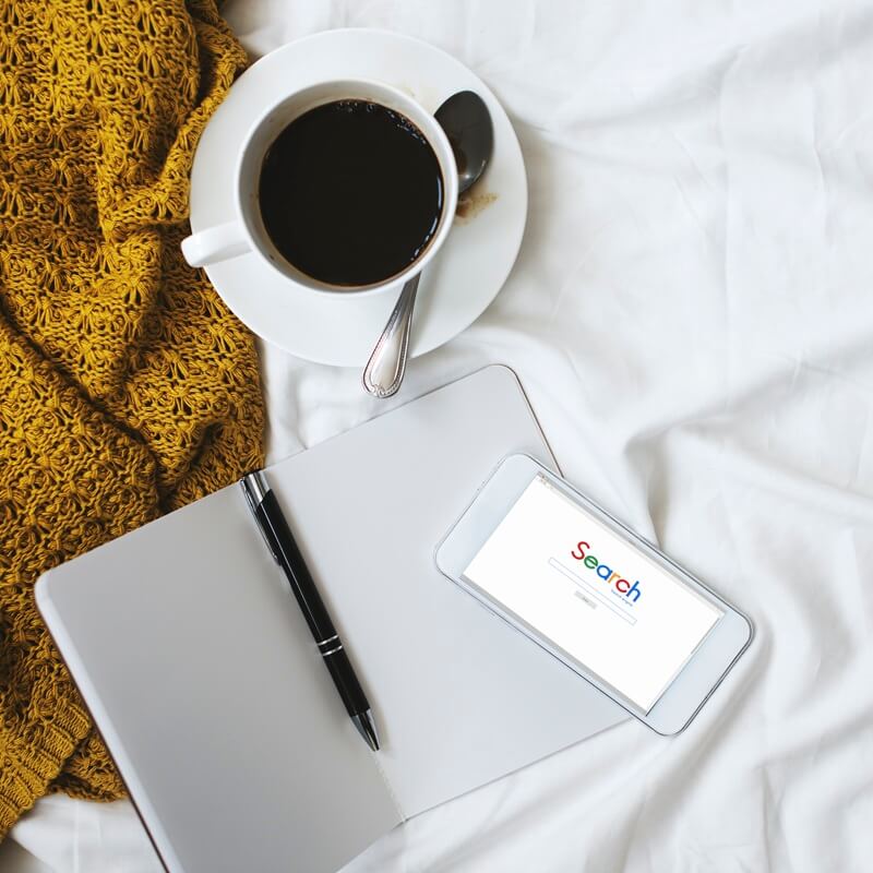 cup of black coffee and mobile devices cup of black coffee, mobile phone with word "search" on screen and a tablet pc with a stylus on it